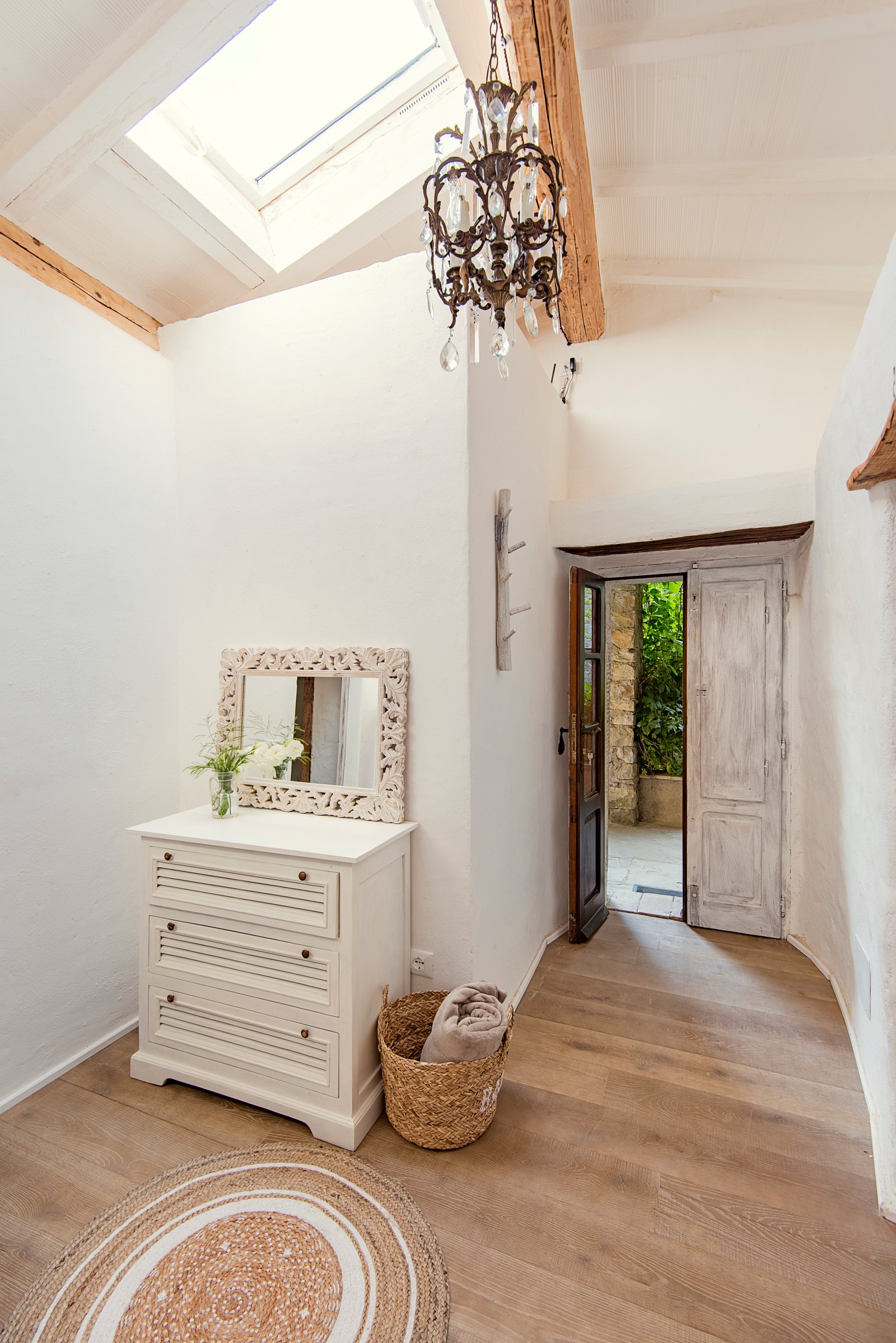 Entrance hall with a skylight, a crystal chandelier and a door open to the garden