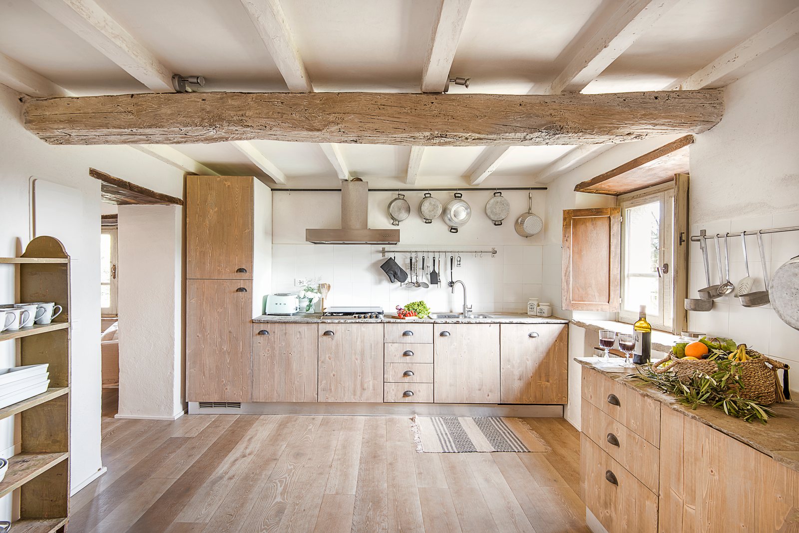 Kitchen with wooden units, a beamed ceiling and an island for cooking