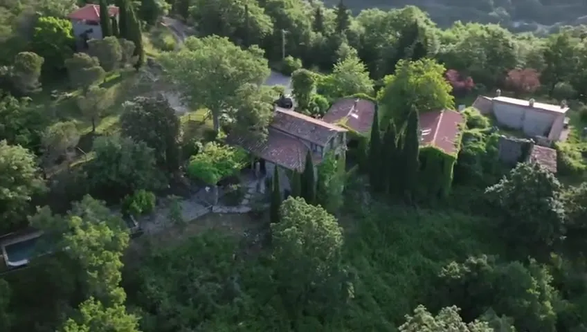 Drone view of Villa Pierle, four stone buildings in the forest above the Val di Pierle